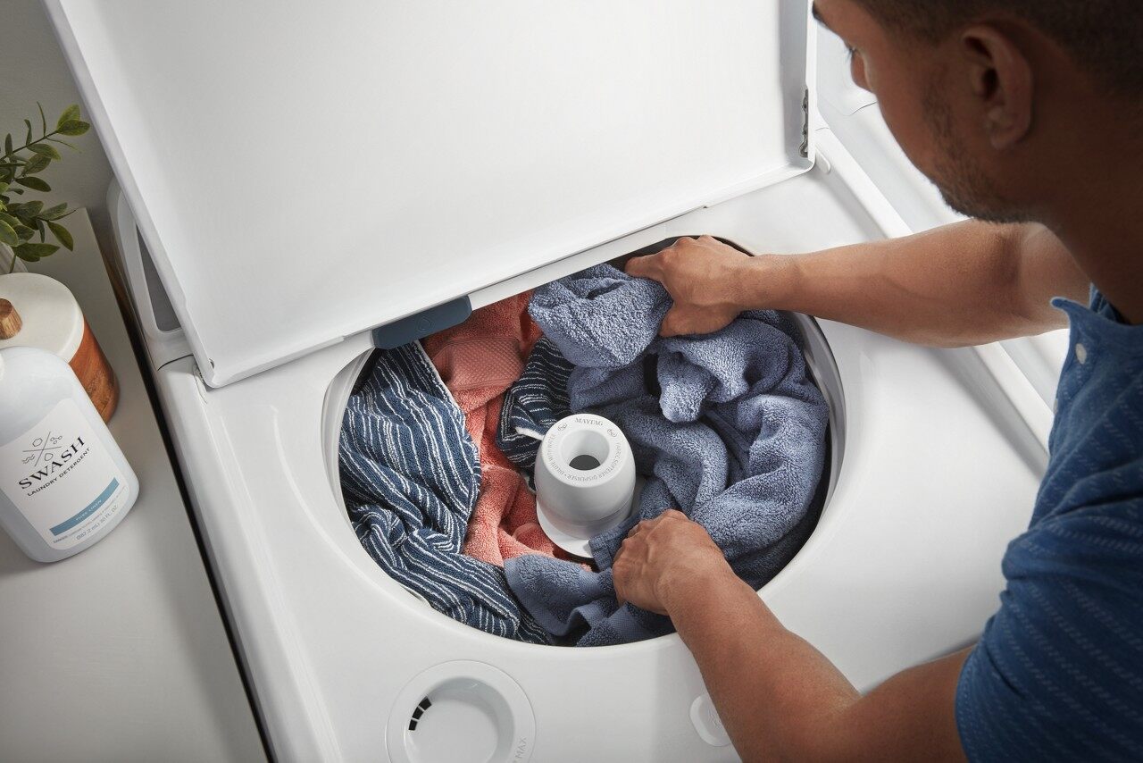 person looking inside washer full of water and not draining