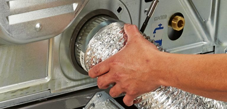 A person attaches the vent hose to a dryer.