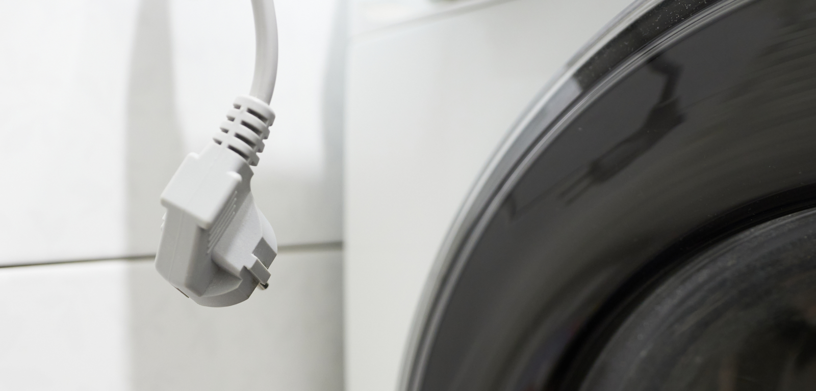 A cord dangles in front of a washer.