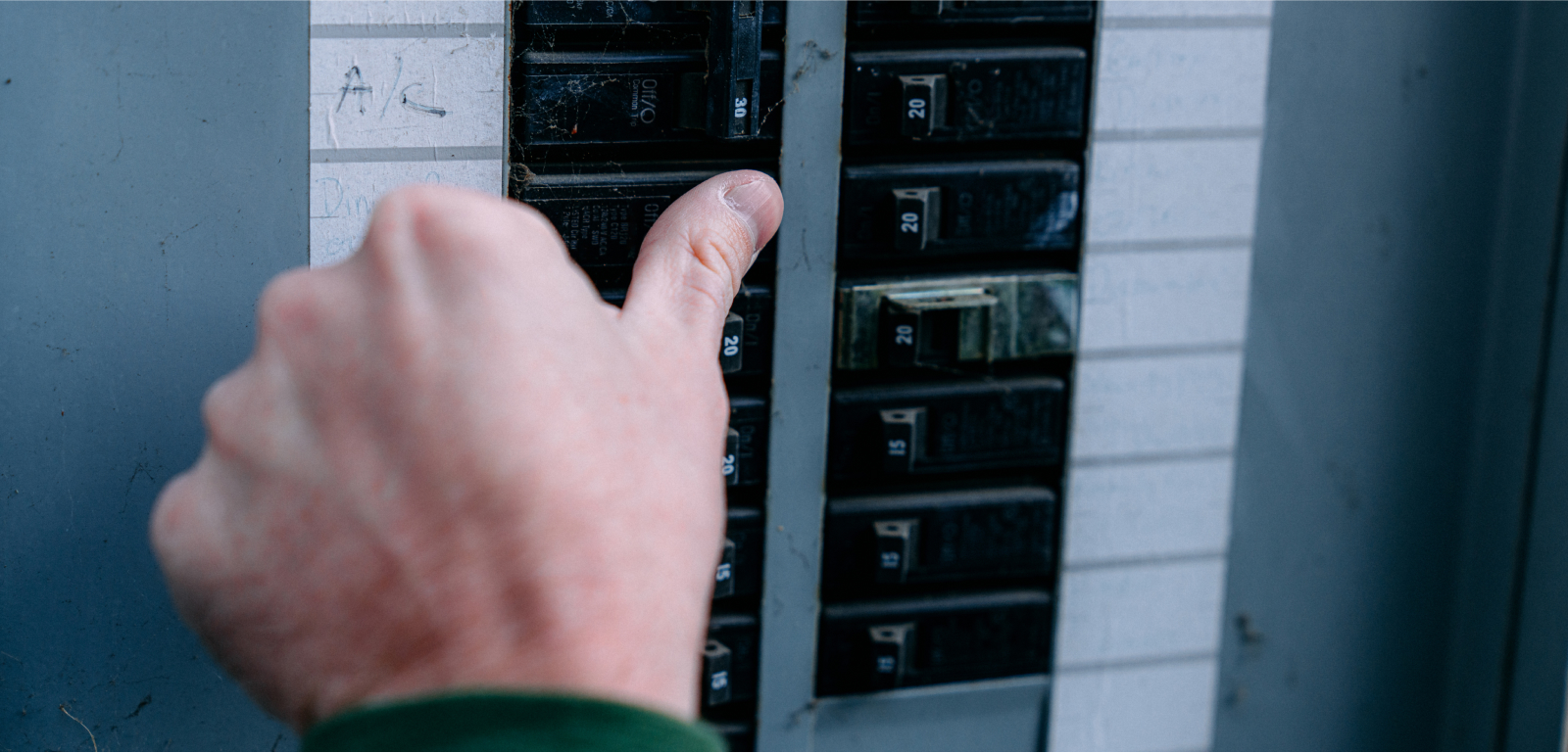 A person flips a breaker.