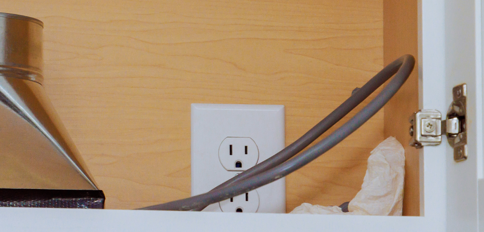 An outlet with a cord in front of it.
