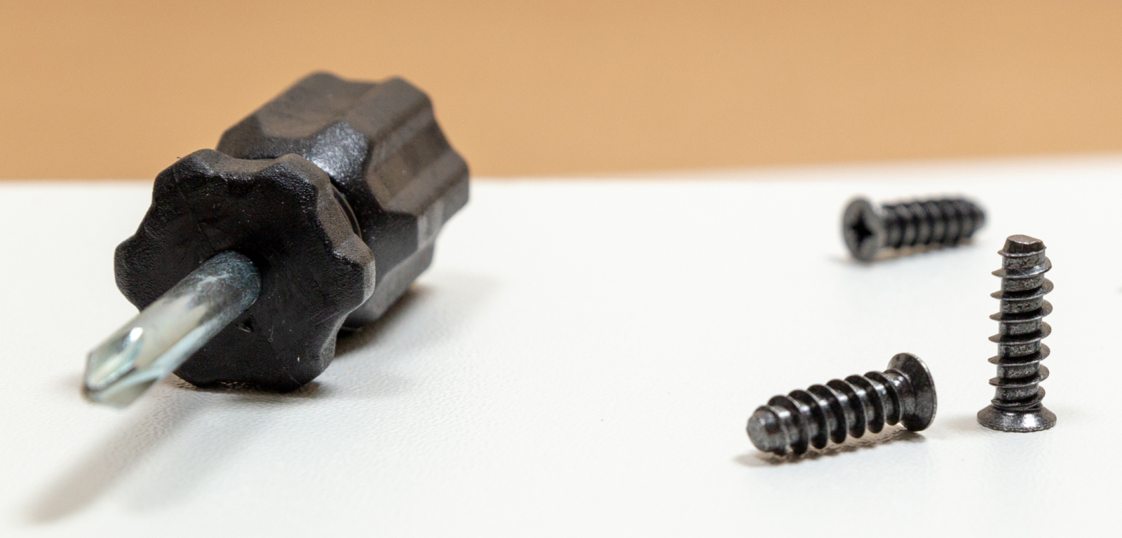 A small screwdriver and three screws