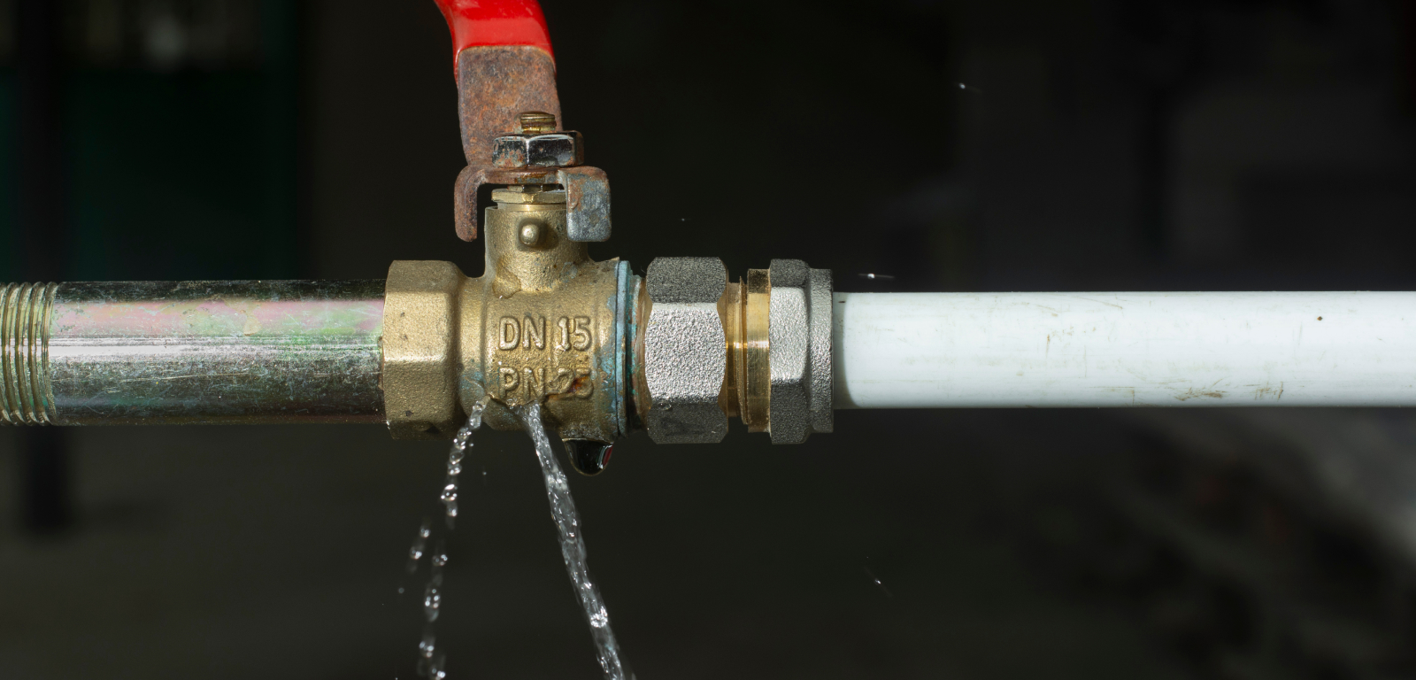 A pipe with a water leak at the connection point.