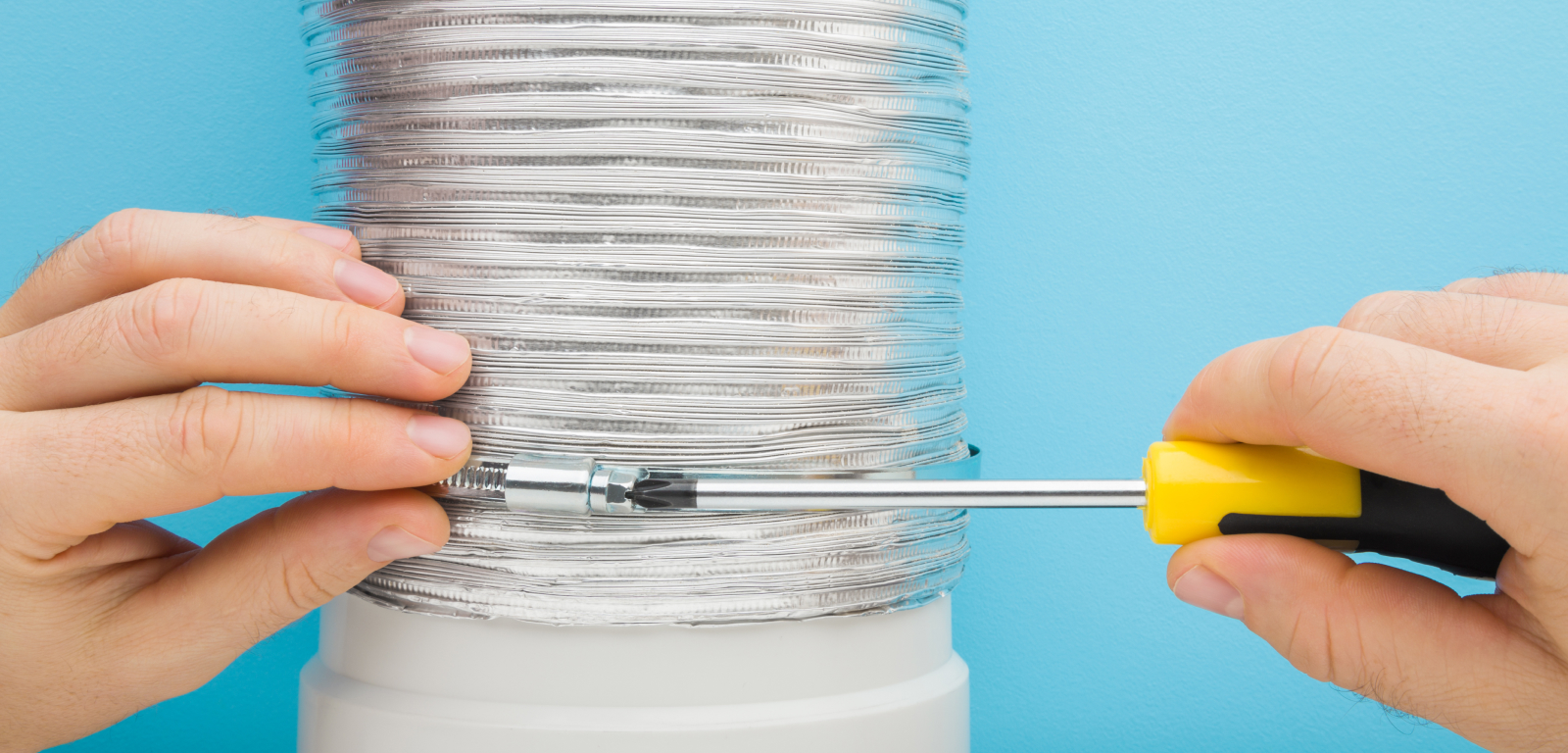 A person tightens the connection on a vent with a screwdriver.