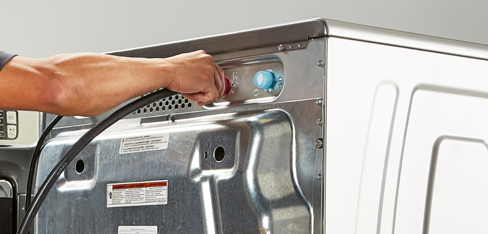 A person installs a washer by attaching the cord.
