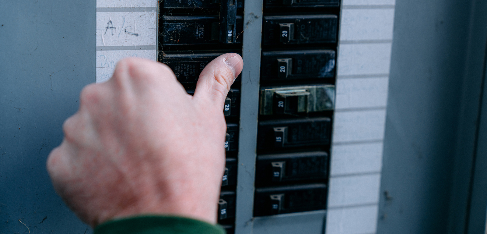 Img_Step1_1600x768 A person flips a breaker in a breaker box.
