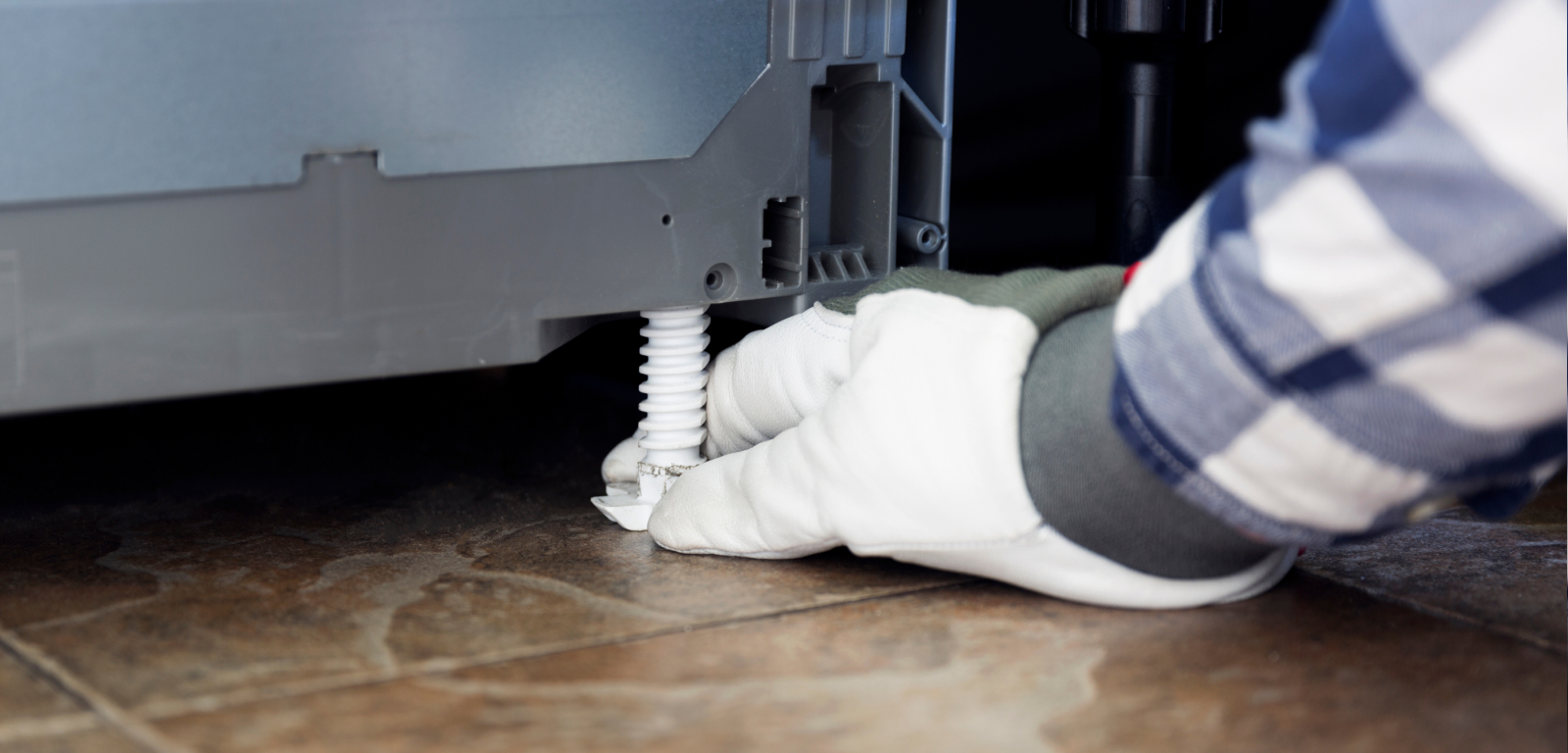 Img_Step8_1600x768 A gloved hand levels a dishwasher.